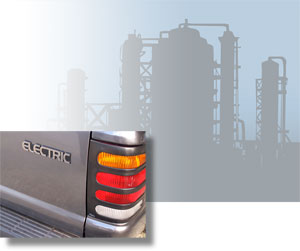 Tail light of an electric truck; silhouette of a refinery.